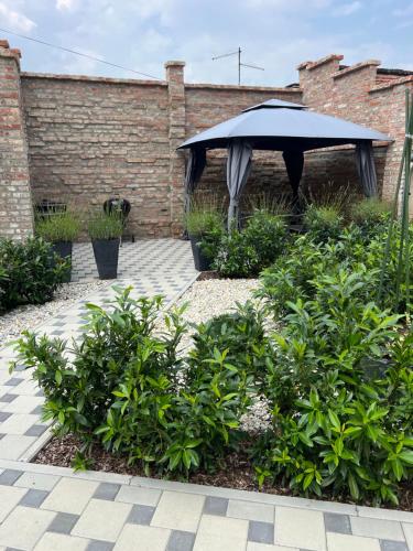 a black umbrella in a garden with bushes at La Luna Rustic Deluxe Apartment with Free Jacuzzi, Bikes & Covered Parking in Našice