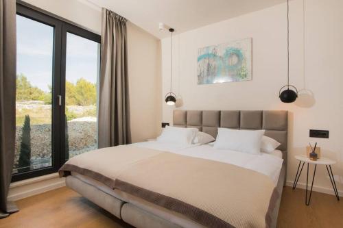 a bedroom with a large bed and a large window at Villa Maris - Luxury Villa with Pool in Brodarica