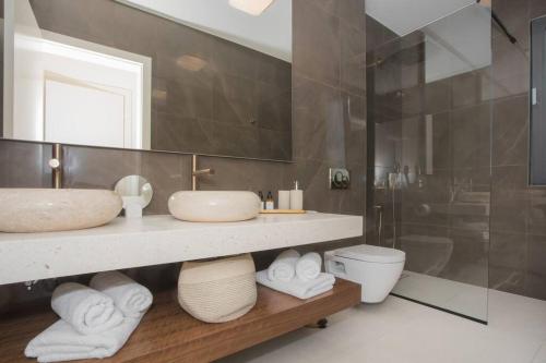 a bathroom with two sinks and a shower and a toilet at Villa Maris - Luxury Villa with Pool in Brodarica