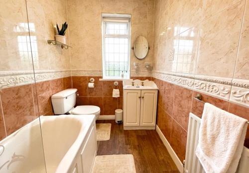 ein Badezimmer mit Badewanne, Toilette und Waschbecken in der Unterkunft Cosy Croft Cottage in Greasbrough