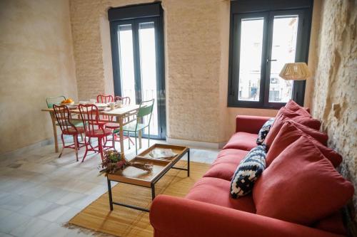 ein Wohnzimmer mit einem roten Sofa und einem Tisch in der Unterkunft San Diego Cathedral Sevilla in Sevilla