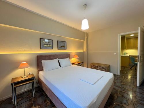 a bedroom with a large bed and two lamps on tables at CELENA CITY in Kalamata