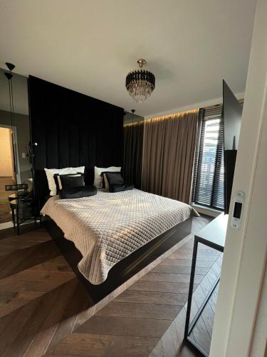 a bedroom with a large bed with a black headboard at Apartament Galaktyczna - prywatne jacuzzi na tarasie in Gdańsk