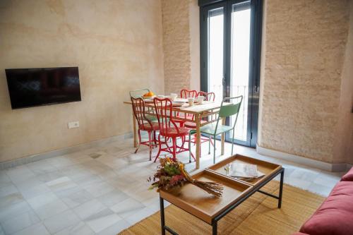 ein Wohnzimmer mit einem Tisch und Stühlen in der Unterkunft San Diego Cathedral Sevilla in Sevilla