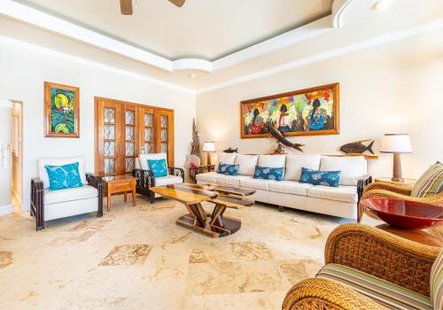 a living room with couches and a table at Belizean Cove Estates Beachfront Villas in San Pedro