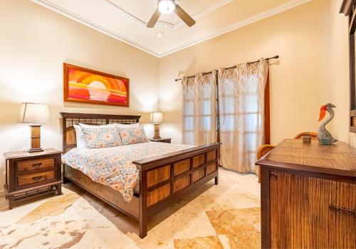 a bedroom with a bed and a desk and a window at Belizean Cove Estates Beachfront Villas in San Pedro