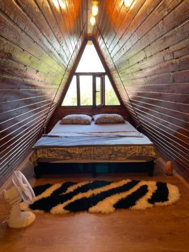 1 dormitorio con 1 cama en una tienda de madera en CABANĀ TIP A LÎNGĀ CASTEl, en Hunedoara