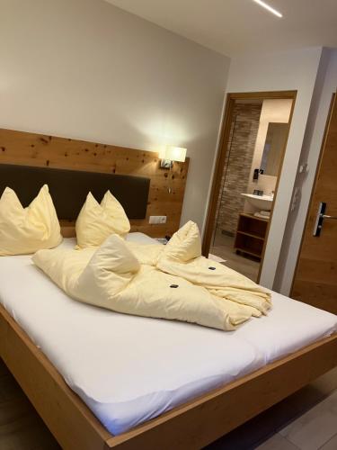 a bed with white sheets and pillows in a room at Hotel Restaurant Waldheim in Martello