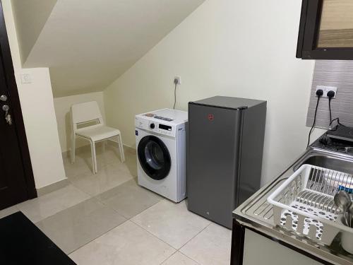 a kitchen with a washing machine and a washer at Your Luxury Studio near Airport in Abu Dhabi