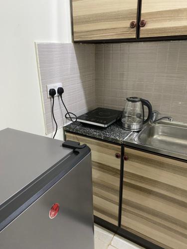a kitchen with a sink and a counter top at Your Luxury Studio near Airport in Abu Dhabi