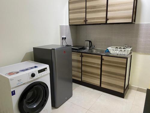 a kitchen with a washing machine and a sink at Your Luxury Studio near Airport in Abu Dhabi