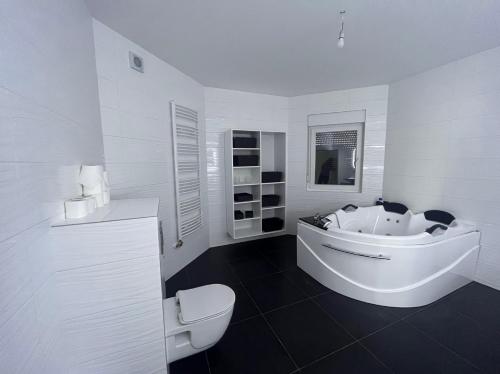 bagno bianco con vasca e servizi igienici di Villa Diamond a Bijeljina