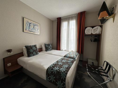 a hotel room with a bed and a window at Timhotel Boulogne Rives de Seine in Boulogne-Billancourt