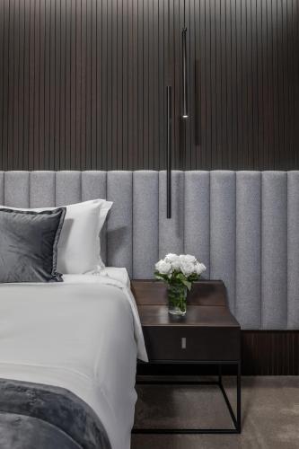 a bedroom with a bed and a table with flowers on it at Derand Hotel in Pristina