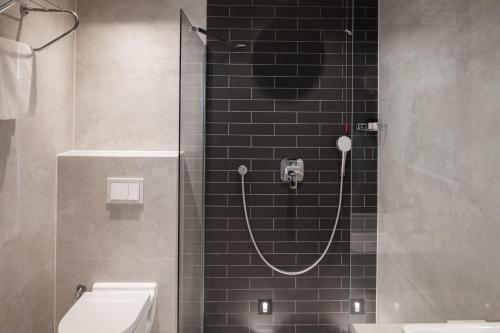 a bathroom with a shower with a sink and a toilet at Derand Hotel in Pristina