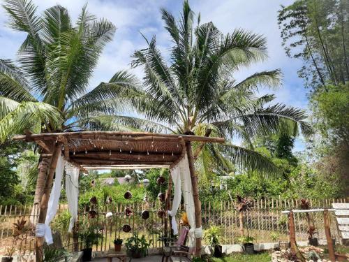 a wooden arch with a palm tree behind it at Lagkaw Uno in Lagkaw Homestay in Panglao