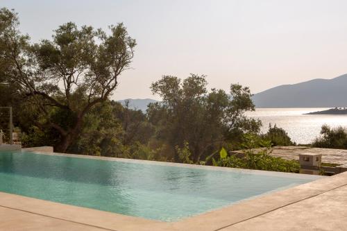 a swimming pool with a view of the water at Villa Sophia-Private Sea Access in Marantochori