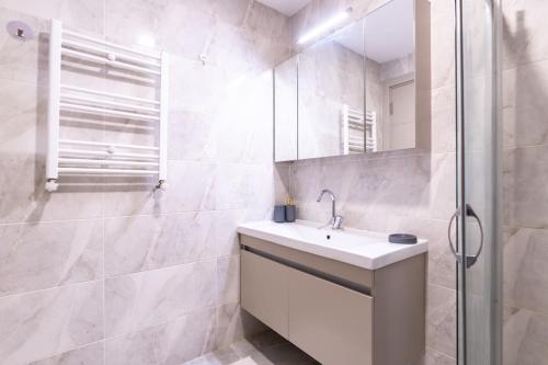een witte badkamer met een wastafel en een douche bij Modern Stylish 2br Apt, Near Eyp Sultan Mosque in Istanbul