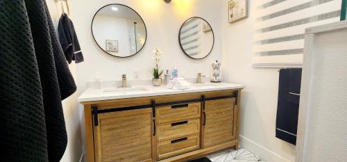 un bagno con lavandino e due specchi sul muro di The Heart Of LA House a Los Angeles