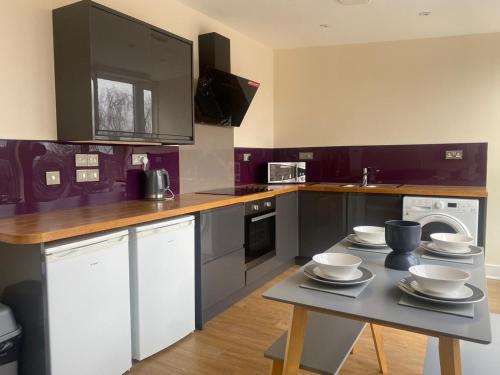 a kitchen with a table with dishes on it at Alexander Apartments South Shields 3 in South Shields