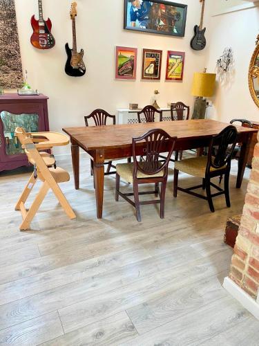 a dining room with a wooden table and chairs at Eclectic Barn - Pergola & Dog-Friendly Garden in Calne