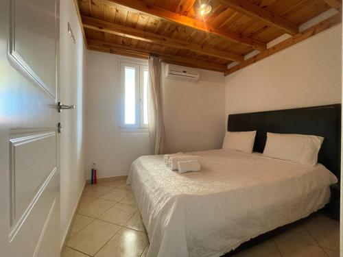 a bedroom with a bed with white sheets and a window at Afroessa apartments in Mesariá