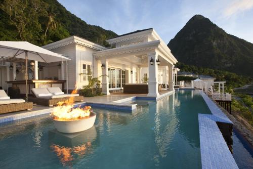 a house with a swimming pool with a fire fountain at Sugar Beach, A Viceroy Resort in Soufrière