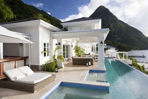 a villa with a swimming pool and a house at Sugar Beach, A Viceroy Resort in Soufrière