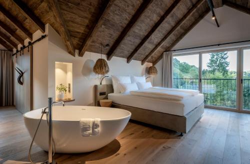 a bedroom with a large bed and a bath tub at Julianhof Premium Guesthouse & Spa in Straden