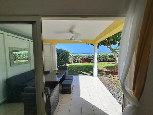 an open door to a patio with a couch at RDC appartement en bord de mer au son des vagues in Le Moule