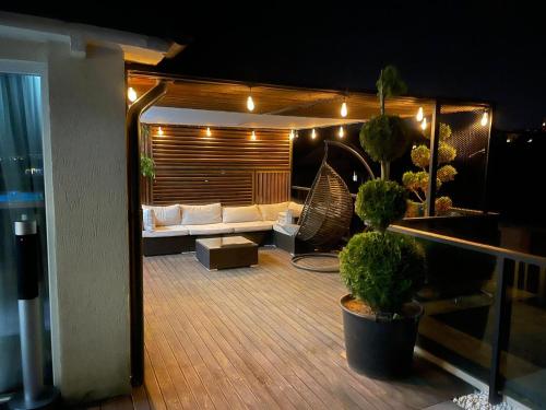 ein Wohnzimmer mit einem Sofa auf einem Balkon in der Nacht in der Unterkunft GAVAS APARTMENTS - Jacuzzi & Panoramic View in Cluj-Napoca