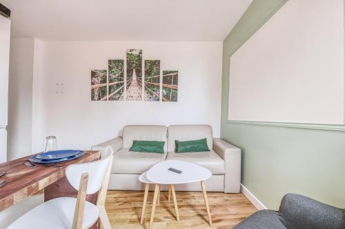 ein Wohnzimmer mit einem Sofa und einem Tisch in der Unterkunft T2 fac centre ville in Rouen