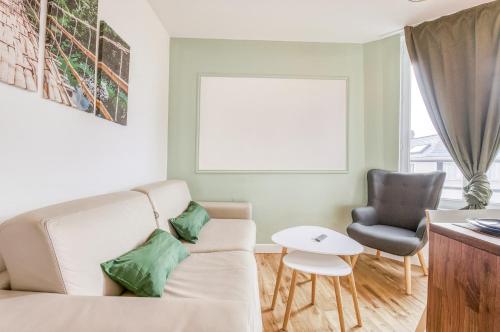 ein Wohnzimmer mit einem Sofa und einem Stuhl in der Unterkunft T2 fac centre ville in Rouen