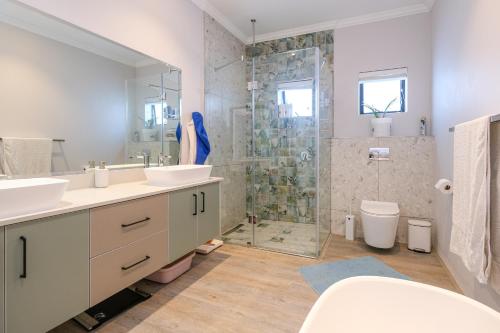 a bathroom with two sinks and a shower at The Halfway House @ Kingswood Golf Estate in George