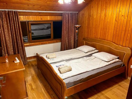 a bedroom with a bed in a room with wooden walls at Spacious, 3BD home in Radauti in Rădăuţi