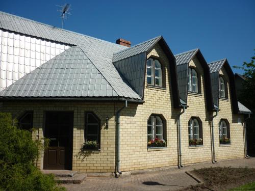 a house with a metal roof and windows at Marigolds in Sigulda