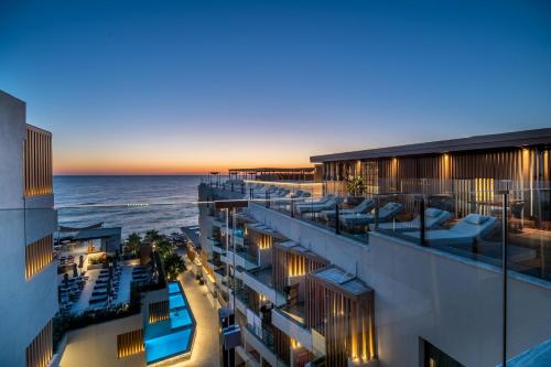 a view of a building with the ocean in the background at AKASHA Beach Hotel & Spa in Hersonissos