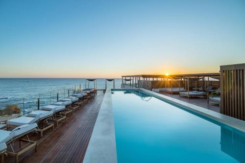 a swimming pool with the ocean in the background at AKASHA Beach Hotel & Spa in Hersonissos