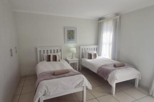 a white room with two beds and a window at Point Village Accommodation - Linda in Mossel Bay