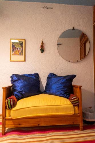 a bench with two blue pillows and a mirror at DAR DAUIA in Chefchaouene