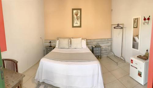 Habitación hospitalaria con cama y 2 mesitas de noche en Suíte no centro histórico en Pirenópolis