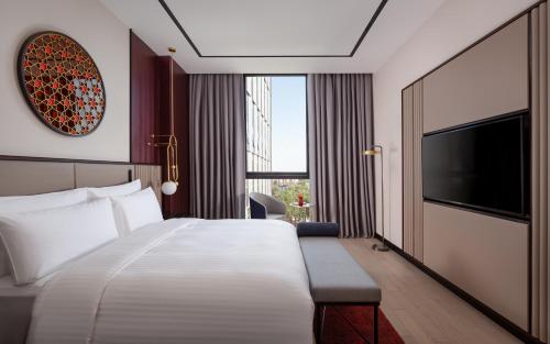 a hotel room with a bed and a flat screen tv at InterContinental Tashkent by IHG in Tashkent