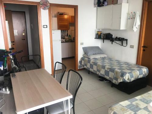 ミラノにあるBisceglie Aparthotelのテーブルとベッド1台付きの部屋、キッチンが備わるアパートメントです。