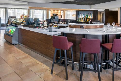紐瓦克的住宿－萬怡紐瓦克自由國際機場酒店，一间酒吧,在旅馆房间设有红色椅子