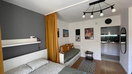 1 dormitorio pequeño con 1 cama y cocina en Harmony apartman, en Donji Milanovac