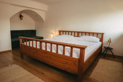 sypialnia z dużym drewnianym łóżkiem w pokoju w obiekcie Turnul Maresalului w mieście Corbeni