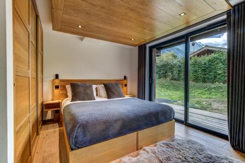 a bedroom with a bed and a large window at Black Pearl in Chamonix-Mont-Blanc