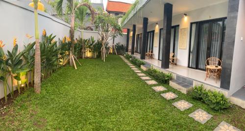 a courtyard of a house with a green yard at Queens Villa in Seminyak