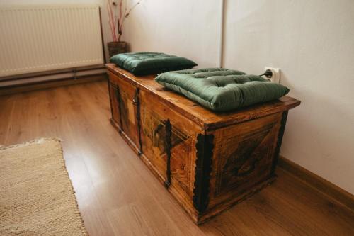 dwie zielone poduszki siedzące na drewnianym stole w obiekcie Turnul Maresalului w mieście Corbeni