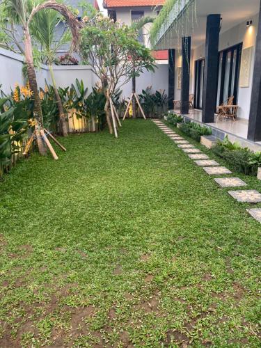 a yard in front of a house with green grass at Queens Villa in Seminyak